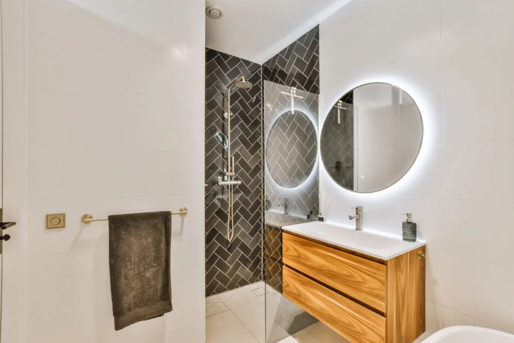 Stunning bathroom with large round illuminated mirror